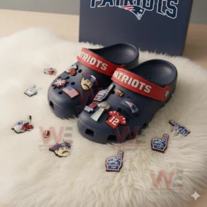 Navy Patriots clogs with multiple charms displayed on a white furry surface!