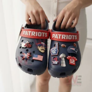 Person holding navy Patriots clogs decorated with team themed charms!