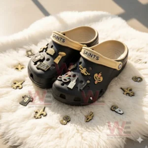 Black Saints clogs with assorted charms surrounded by scattered gold charms on white fur!