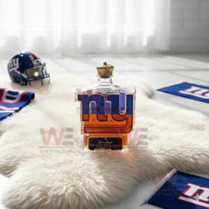 A transparent logo shaped bottle filled with amber liquid is placed on a white rug with a helmet and team cloth in the background!