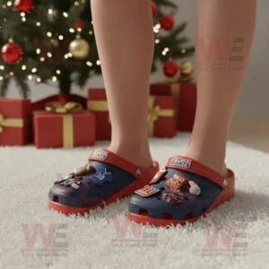 Person wearing New York Giants Crocs beside a Christmas tree with gifts on a soft carpet!