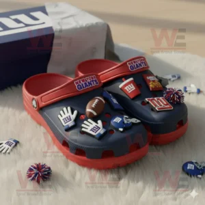 New York Giants Crocs with themed charms beside a team logo box on a white rug!