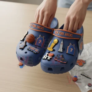 Person wearing New York Knicks-themed Crocs with basketball-related charms.