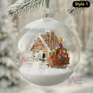 Alt text: Snoopy in front of a gingerbread house with gifts inside a Christmas ornament.