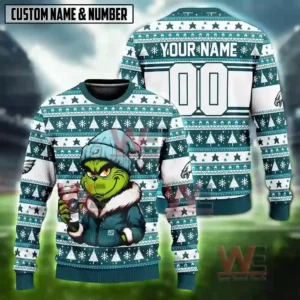 Alt text: A custom Philadelphia Eagles Grinch sweater with a personalized name and number, featuring the Grinch holding a coffee cup.