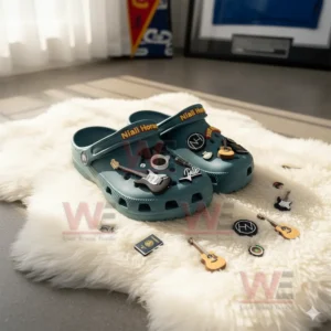 Teal Crocs with Niall Horan music themed charms on a white fur rug in a bright room!