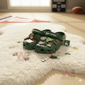 Green Noah Kahan Crocs with themed charms on a white fluffy rug in soft natural lighting!