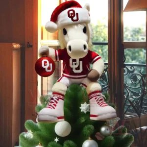 A white horse mascot in Oklahoma Sooners outfit and Santa hat sitting on a Christmas tree holding a red OU ornament!