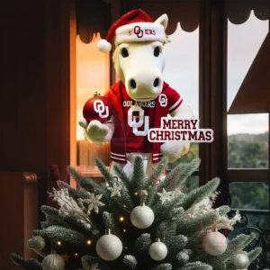 A white horse mascot wearing a Santa hat and Oklahoma Sooners uniform standing on a Christmas tree holding a Merry Christmas sign!