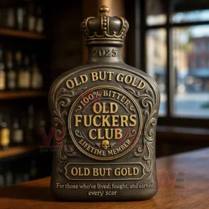 A gold accented bottle stands on a wooden table with bar shelves and a window in the background!