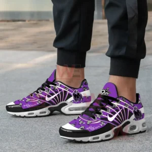 A close-up of a person wearing Ozzy Osbourne-themed sneakers with purple, black, and white graphics, including bats and skulls.