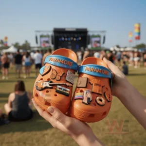 Paramore Crocs with Charms 8 Hands holding orange Paramore Crocs with bright charms at a music festival outdoors!