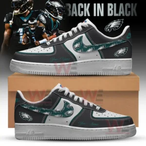 A pair of custom black and white shoes with green eagle graphics on the sides shown in front of a background featuring football players in black uniforms!