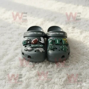 Philadelphia Eagles Crocs with themed charms on a white fluffy rug!