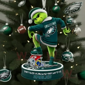 A green character in a dark green outfit stands on a round team themed ornament hanging from a Christmas tree decorated with green silver and football ornaments.