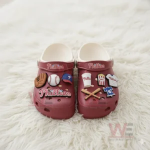 Red Phillies clogs with multiple baseball themed charms displayed on a white furry surface.