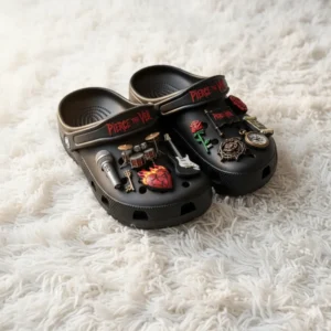 Black Pierce The Veil Crocs with guitar and drum charms on white carpet.