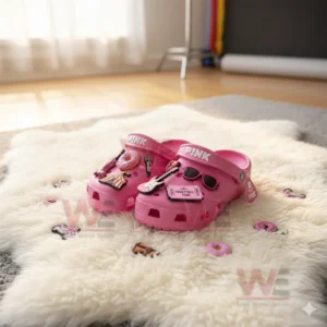 Pink clogs with multiple music themed charms displayed on a white furry rug!