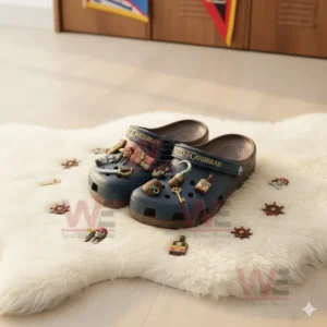 Alt text: Pirates of the Caribbean Crocs clogs with pirate-themed charms displayed on a white rug, surrounded by small pirate accessories.