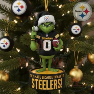 A green character in a black team jersey stands on a round ornament hanging from a Christmas tree decorated with black gold and white baubles.