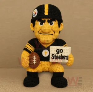 Crocheted black and yellow football character holding a brown football and a stitched sign!