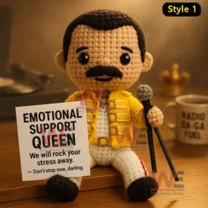 Queen Band Emotional Support Doll 7 A crochet doll in a yellow jacket holding a microphone and a sign with an encouraging message!