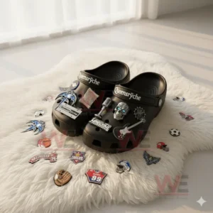 Black clogs with Queensryche logos and themed decorations are placed on a soft white rug with assorted patches nearby.