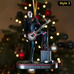 A guitar player ornament posing on a suspended platform in front of a Christmas tree.