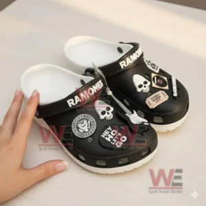 Black charm decorated Ramones clogs being handled on a table!