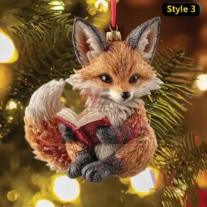 Christmas ornament of a fox reading a book hanging from a Christmas tree with warm lights!