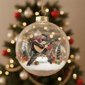 Ornament with a man in red holiday clothing standing in snow with trees and gifts.