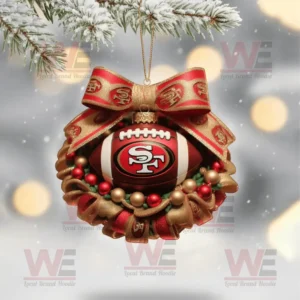 A San Francisco 49ers Christmas football ornament with gold and red ribbon hanging from a snowy pine branch!