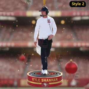 Alt text: Kyle Shanahan, head coach of the 49ers, walking on the field with a clipboard, captured as a Christmas ornament.