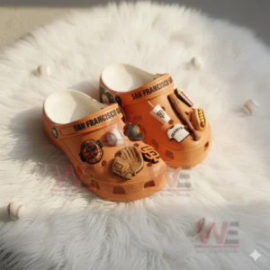 San Francisco Giants Crocs with baseball and snack themed charms placed on a white furry surface!