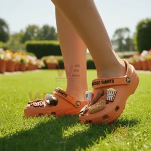 Person wearing San Francisco Giants Crocs decorated with baseball themed charms on grassy field!