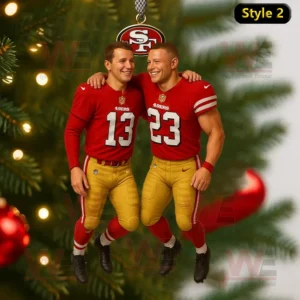 A San Francisco 49ers themed ornament featuring two players in red uniforms with gold pants smiling and embracing on a decorated Christmas tree!
