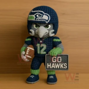 Crocheted blue and green hawk themed football figure holding a brown football and a stitched sign.