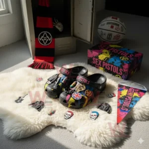 Sex Pistols Crocs Clogs with Charms 6 Black Sex Pistols clogs with punk-inspired decorations displayed on a white rug with small band-related items.