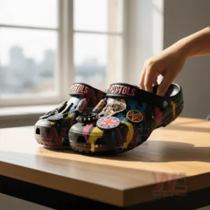 Sex Pistols Crocs Clogs with Charms 7 Black Sex Pistols clogs with bright punk decorations placed on a sunlit wooden table.