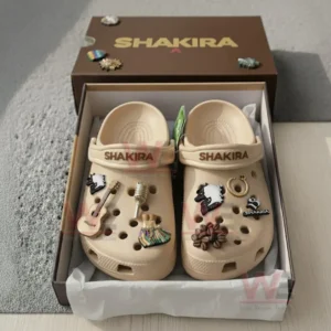 Beige Shakira Crocs inside brown box with musical charms and decorative details!
