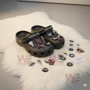 Black Shinedown clogs with detailed decorations displayed on a fluffy white rug with accessories around.