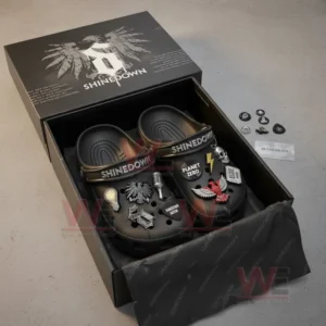 Open box showing black Shinedown clogs with band-inspired charms and accessories beside them.