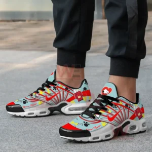 A close-up of a person wearing Snoopy-themed sneakers with a custom name, featuring Snoopy illustrations, bones, and candy graphics.