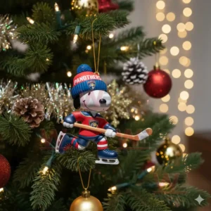 A cartoon dog hockey ornament hanging on a lit Christmas tree surrounded by holiday decorations!