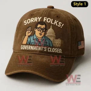 Brown cap with cartoon man waving and text Sorry Folks Government’s Closed plus US flag patch.