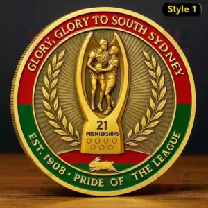 A gold commemorative coin with two rugby players and text celebrating 21 premierships of the South Sydney Rabbitohs.