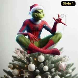 The Grinch dressed as Spider Man wearing a Santa hat sitting cross legged on a Christmas tree decorated with white ornaments and lights!