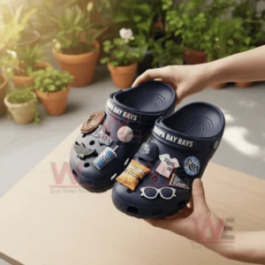 Person holding blue Tampa Bay Rays Crocs with baseball charms outdoors in natural light!