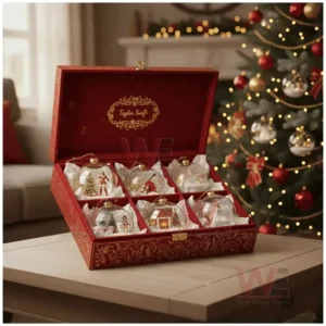 Taylor Swift Snowball Christmas Ornament 3 Red decorative box with six Taylor Swift themed Christmas ornaments beside a glowing holiday tree!