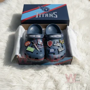 Navy blue Tennessee Titans Crocs with football-themed charms displayed inside a branded Titans box.